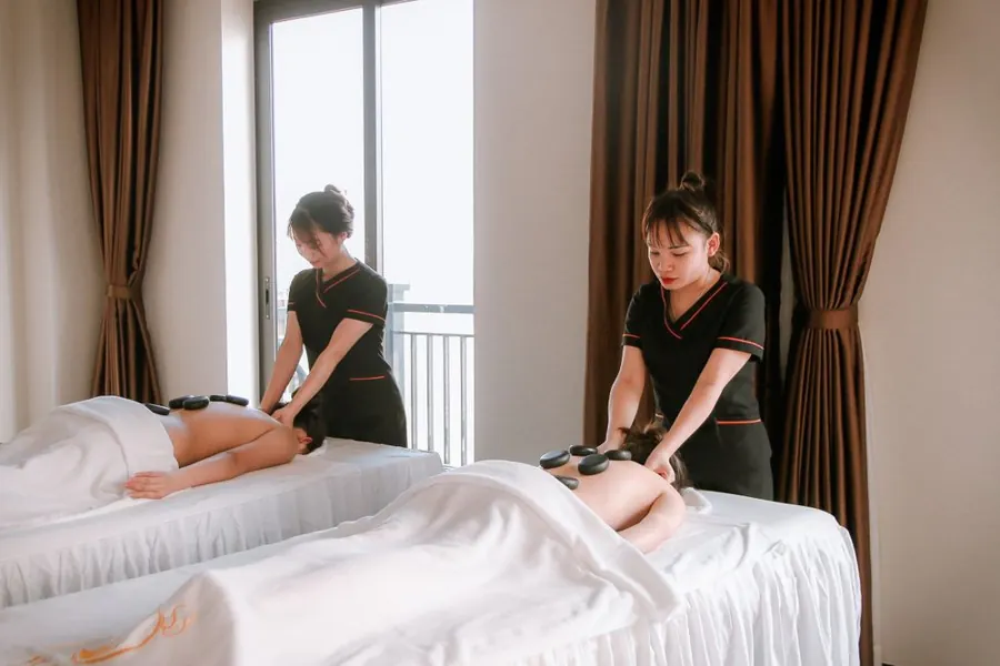Two practitioners attending to clients in a shared spa setting
