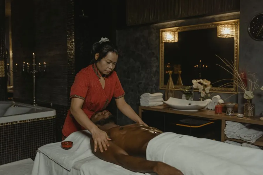 Female practitioner performing a back massage for an adult man