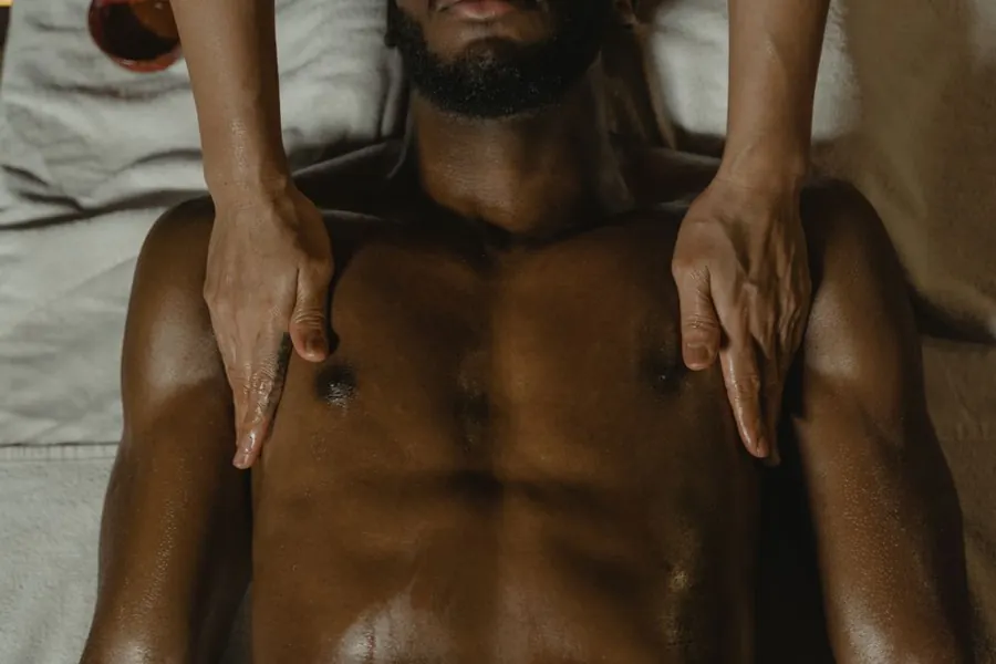 Close view of an adult man receiving a shoulder treatment