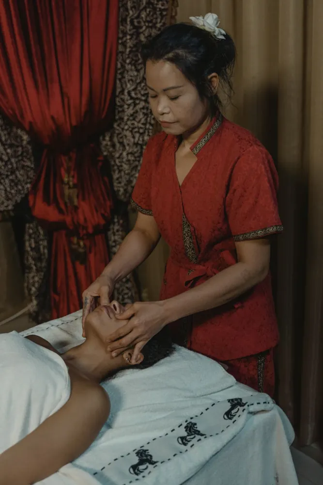 Practitioner attending to a client in a softly lit treatment room